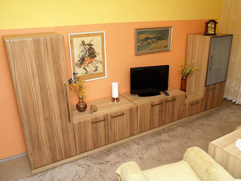 I v obývacím pokoji je nábytek na míru - dekory Ořech Limousine a Dub skořicový